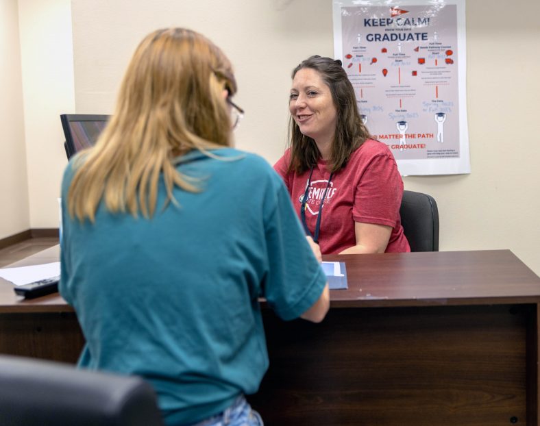 Seminole State College Recruitment Specialist Britney Honsinger helps a student enroll for the fall semester on June 17.