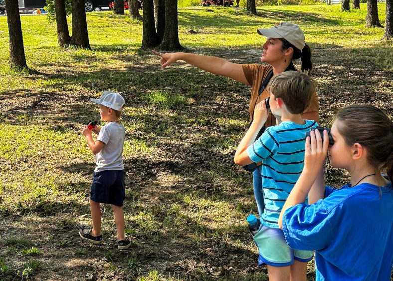 In this photo, SSC agriculture alumni and Oklahoma State University graduate student McKenzie Sheldon takes participants bird watching as part of the Outdoor session.