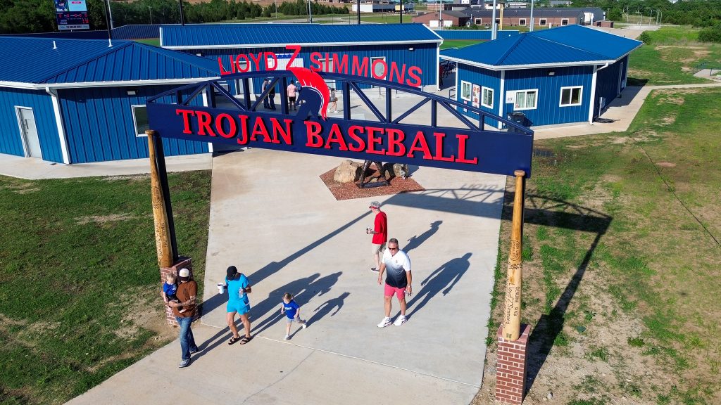 An arch now greets guests as they arrive at the field is shown here. The arch reads Lloyd Z Simmons Trojan Baseball.
