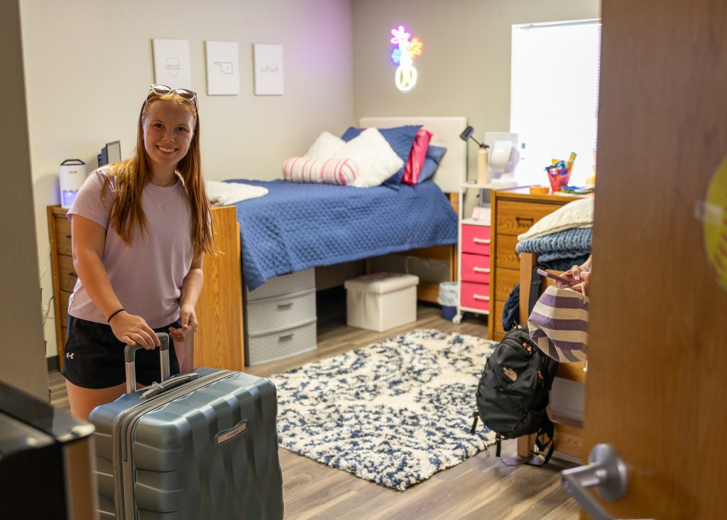 In this photo, SSC freshman and softball team member Olivia Brown of Collinsville puts the finishing touches on her new dorm room.