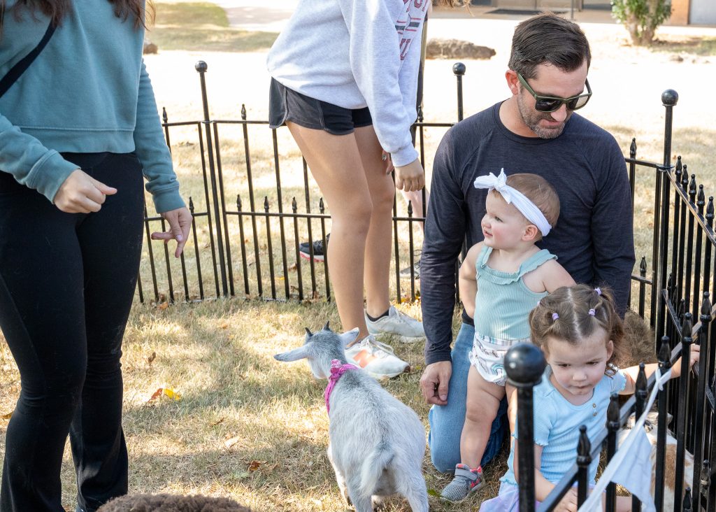 In this photo, SSC Adjunct Professor of Earth Sciences Kevin Blackwood and his daughters, Ember and Everly, play with baby goats at the event.