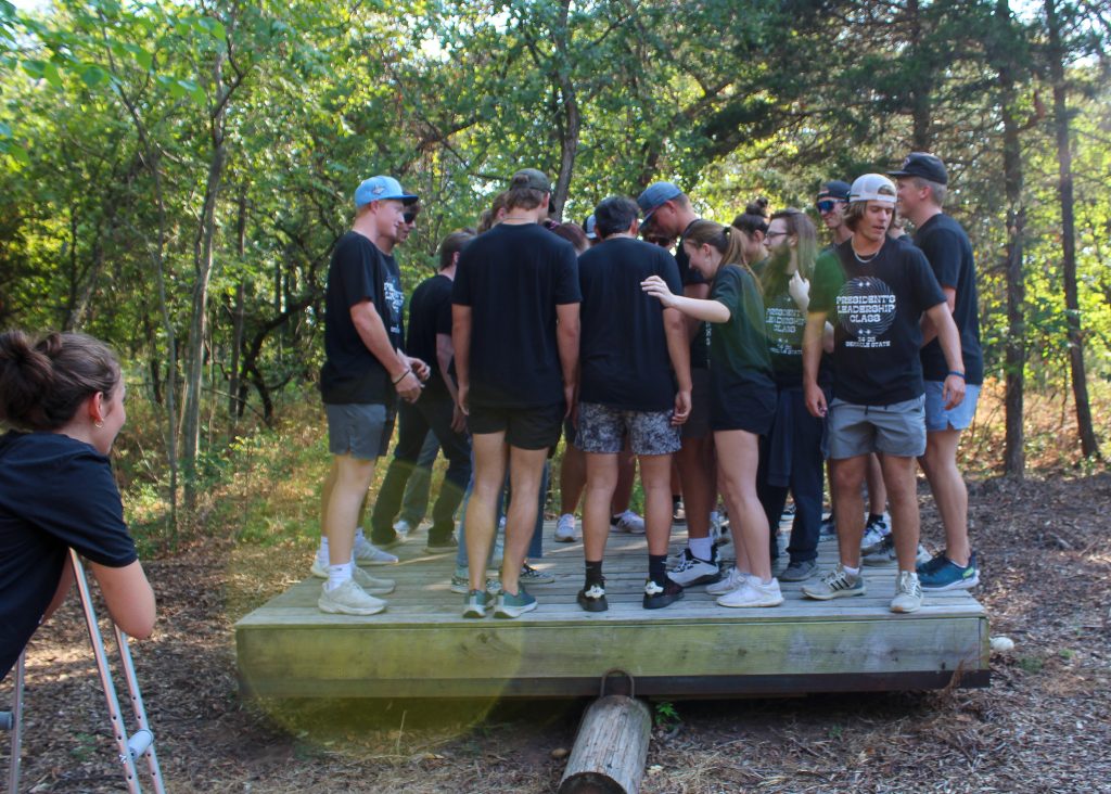 In this photo, a group of SSC PLC students balance together on a platform during a teambuilding exercise. 