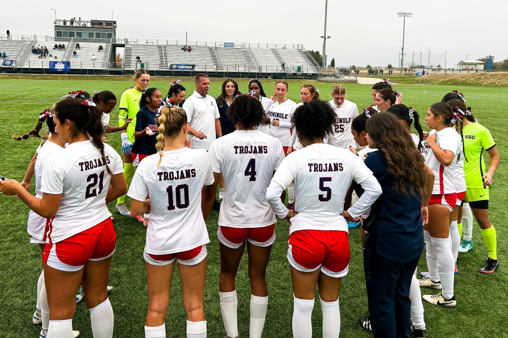 In this photo, the Seminole State College women’s soccer team huddles around Head Coach Dan Hill.