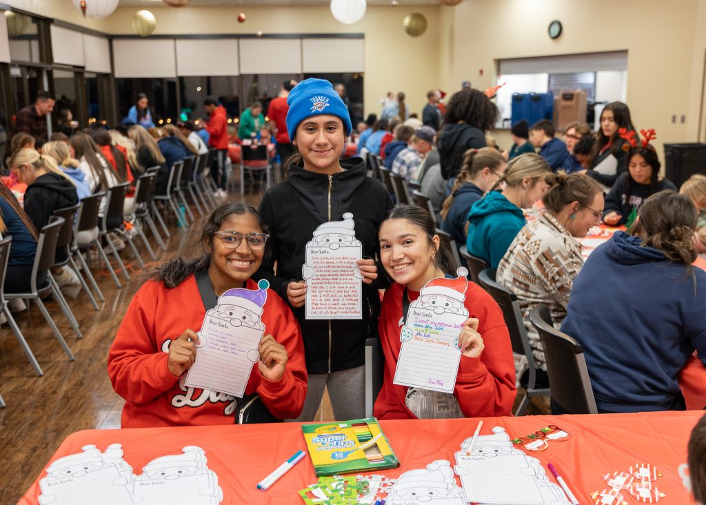 In this photo, Seminole State College student athletes and children from the community decorate letters to Santa.