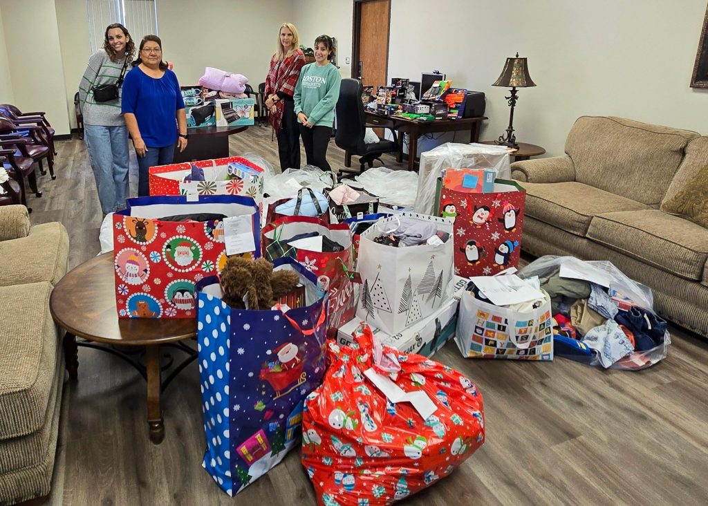 In this photo, pictured (left to right): freshman Kennedy Hudgins of Seminole, Academic Affairs Administrative Assistant Tina Morris, Student Affairs Administrative Assistant Toni Wittman and freshman Aubree Wilkins of Earlsboro, pose for a photo with gifts for 25 children in need. These gifts were donated by SSC employees through the Angel Tree program.