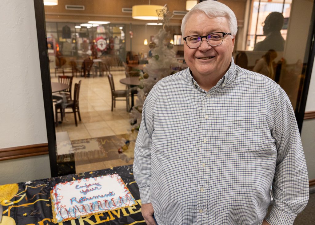 In this photo, IT Technician David Cobb poses with his retirement reception cake.