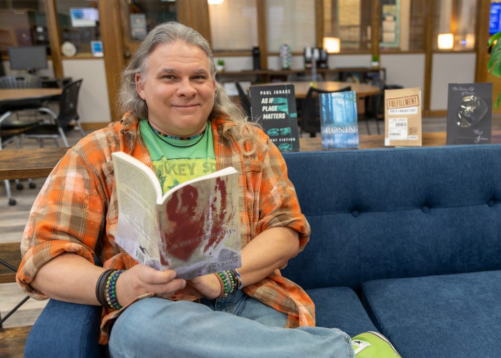 In this photo, Seminole State College Assistant Professor of English Paul Juhasz poses with his published works. The author was recently nominated for a Pushcart Prize for his flash memoir “Row.”