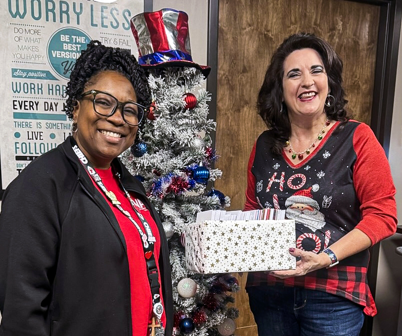 In this photo, Se’Naqua Hildreth (left), the Voluntary Service Assistant with the Center for Development and Civic Engagement at the VA Medical Center, accepts holiday greeting cards signed by the SSC campus community from Professor of History Marta Osby (right).